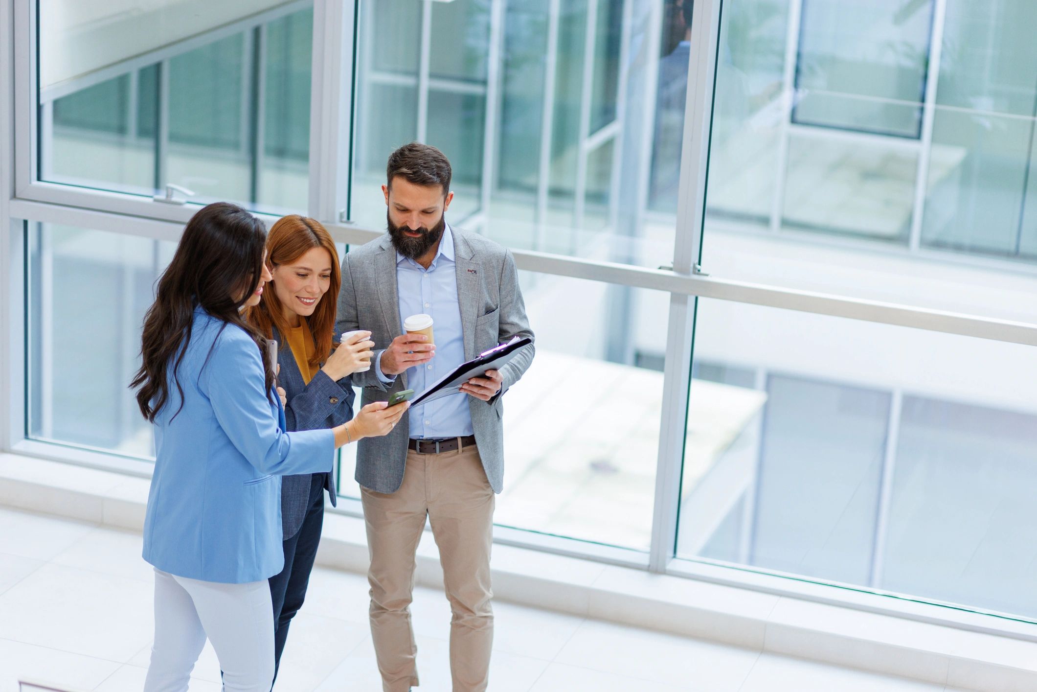 Business colleagues reviewing documents and a smartphone in a modern office
